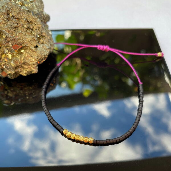 Bransoletka na cienkim bordowym sznurku z czarnymi koralikami i srebrem